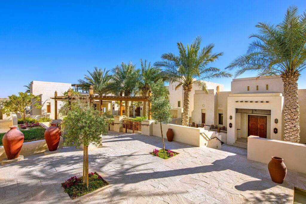 The arched entrance and landscaped courtyard of Al Wathba, a Luxury Collection Desert Resort and Spa