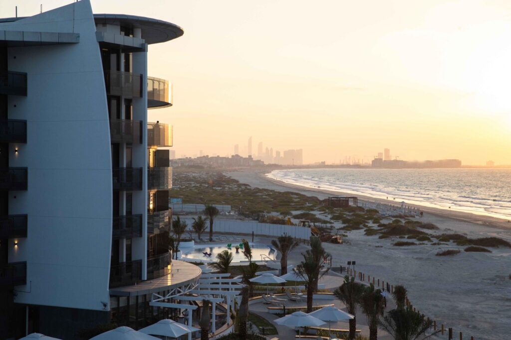 The long low glass facade of Jumeirah Saadiyat Island seen from the beach at sunset