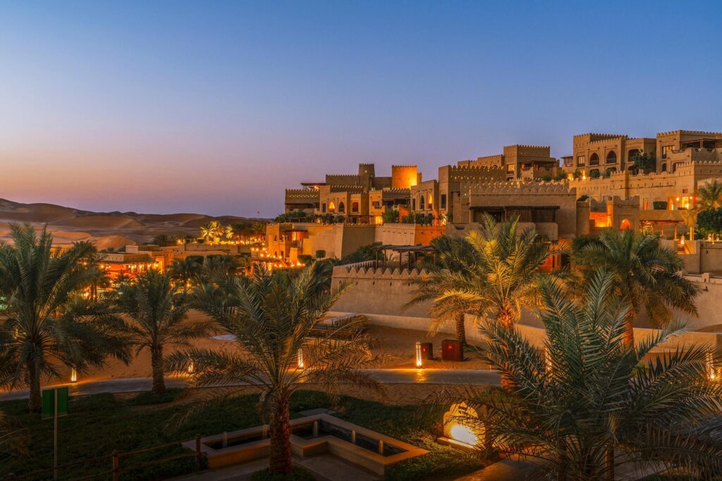The fort walls of Qasr Al Sarab rising from the Liwa dunes at sunset