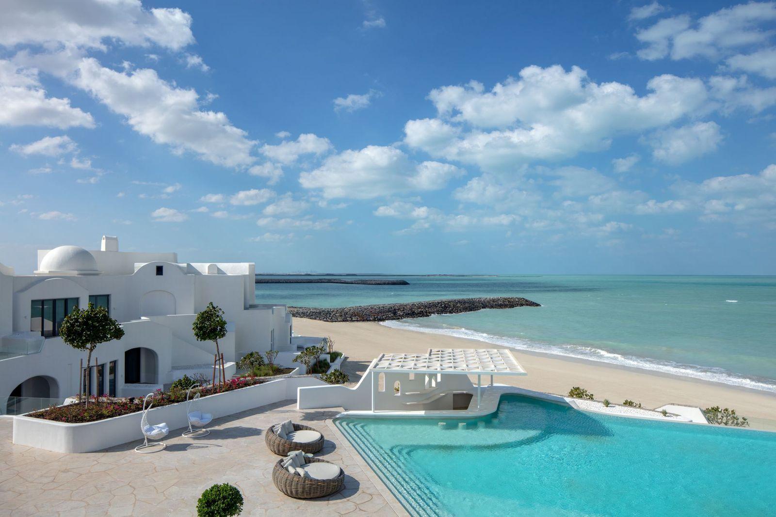 The swimming pool at Anantara Retreat Santorini with the Arabian Gulf beyond