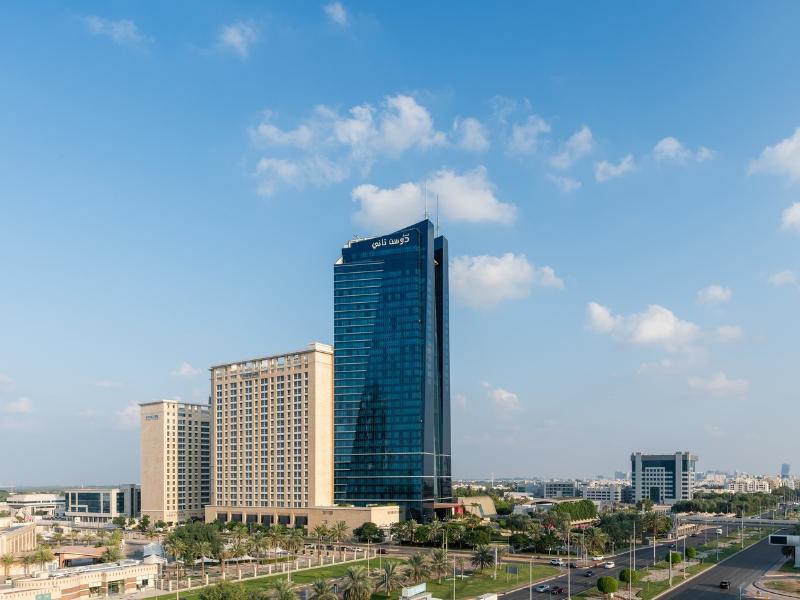 The glass facade and sculptural base of the thirty seven floor Dusit Thani tower