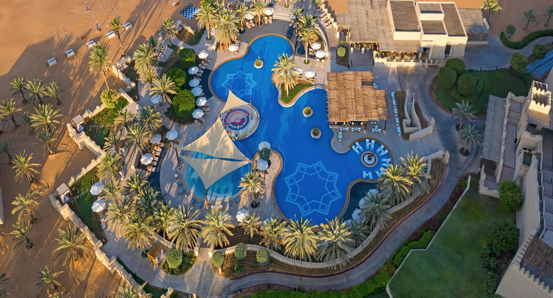 The lagoon style pool fringed with palms at Qasr Al Sarab