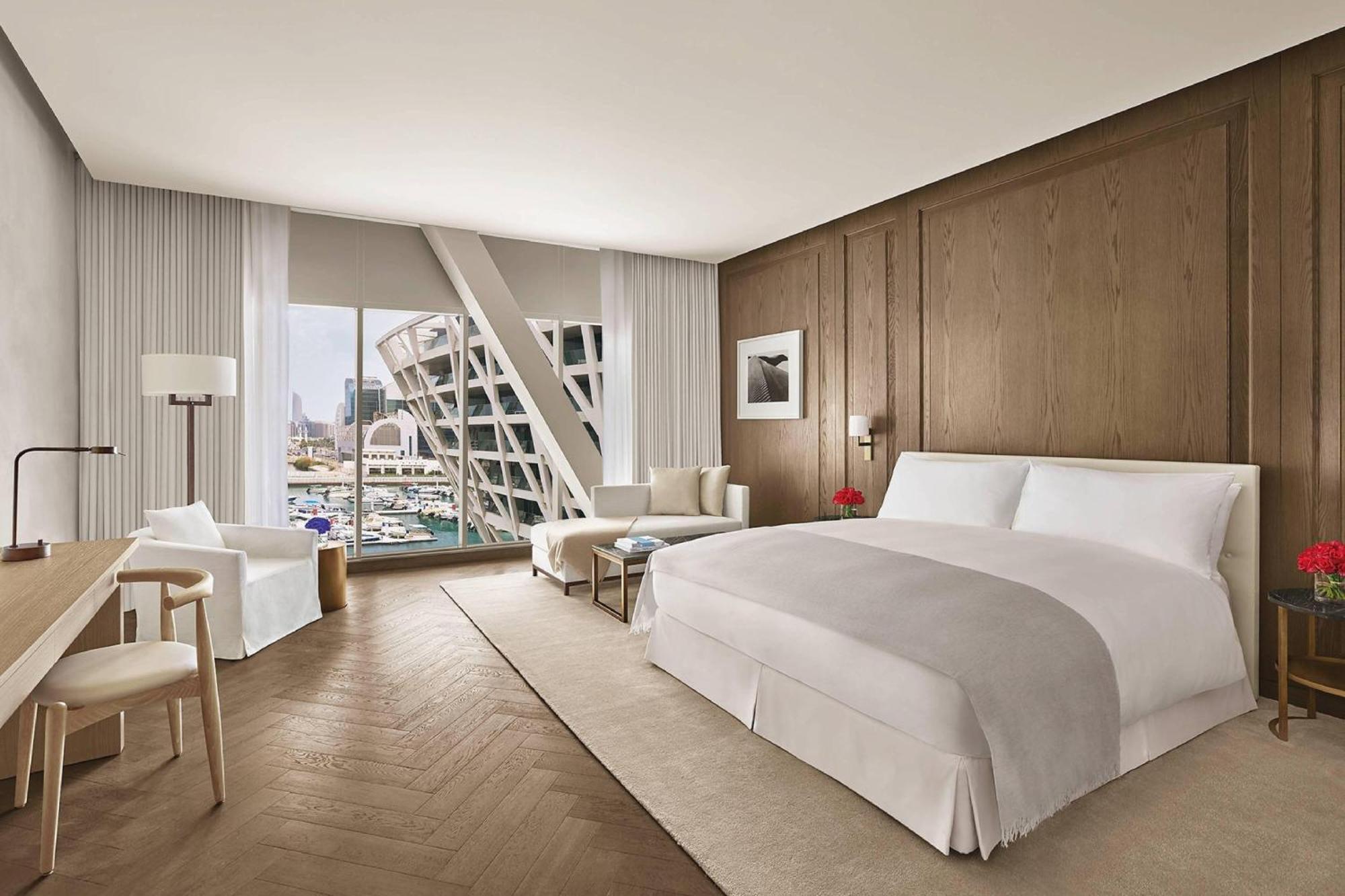A marina facing room with floor to ceiling glazing and a marble bathroom