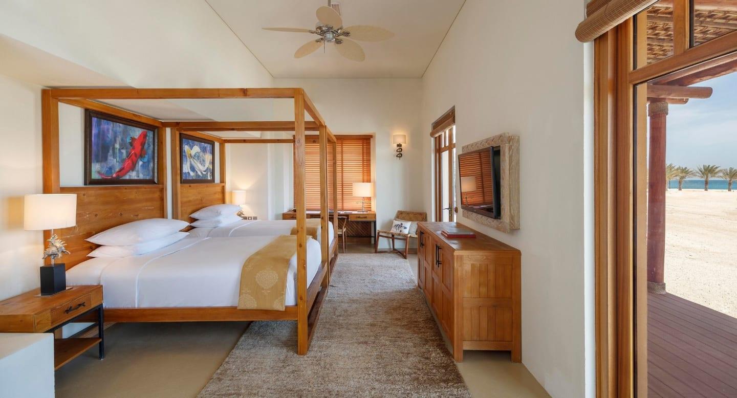 A villa interior with premium bedding and doors opening onto the terrace