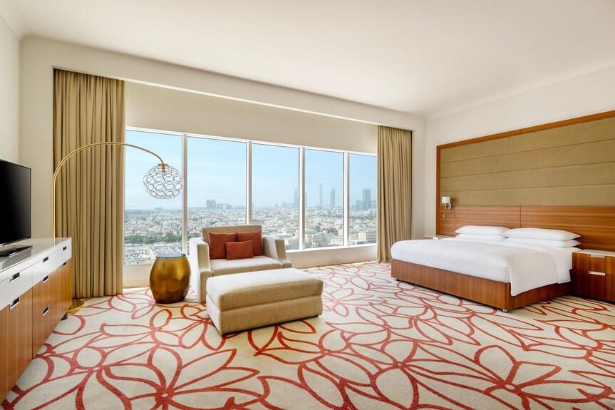 A deluxe king room with a city view and a full work desk
