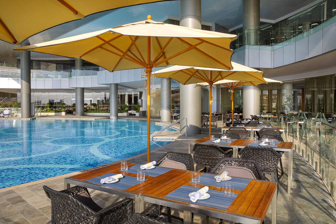 Nahaam outdoor dining with pool and Arabian Gulf views at Conrad Abu Dhabi