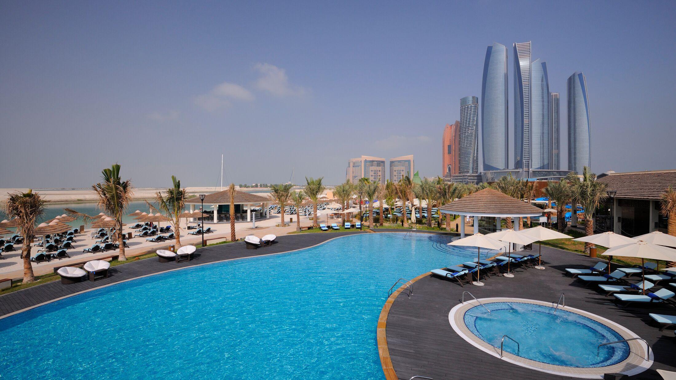The outdoor infinity pool with the children's splash pool and slide beyond