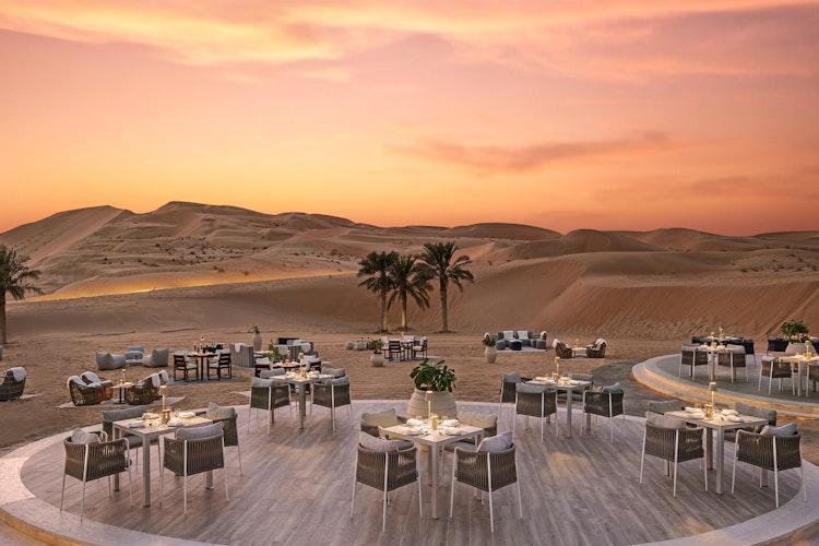 Tables set in the open air at Al Falaj, the Bedouin style dining setting among the dunes