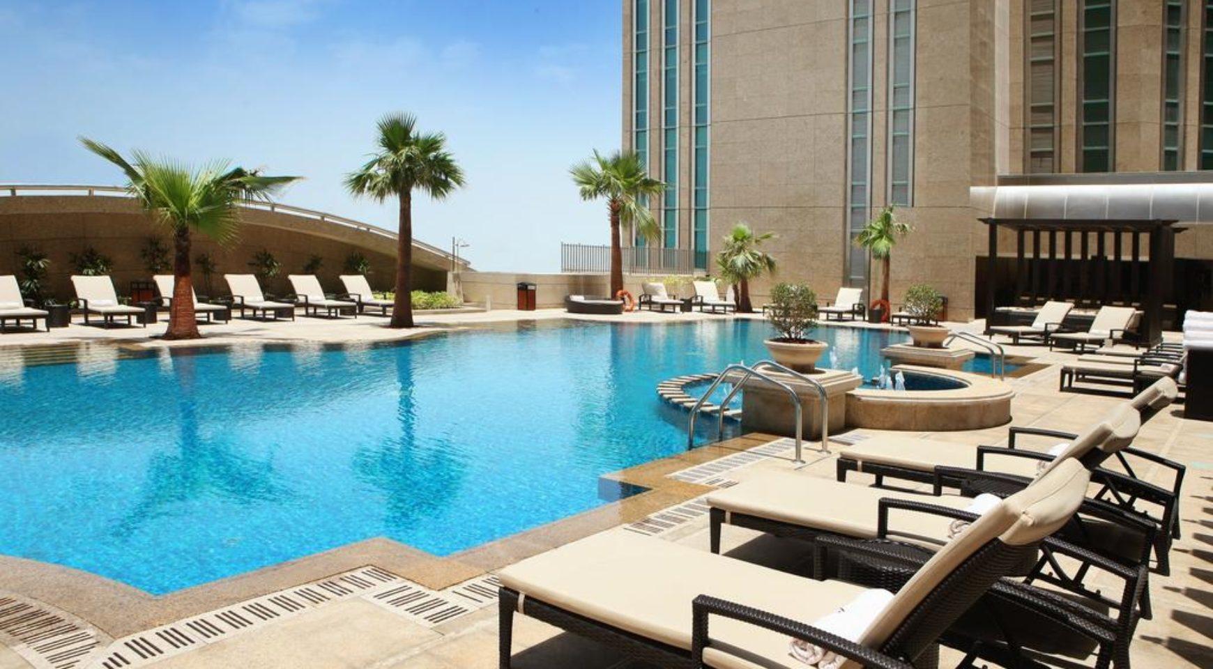 One of the two outdoor pools with loungers, umbrellas and the poolside bar