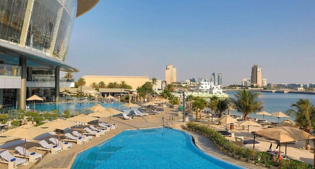 One of the three outdoor pools with loungers and umbrellas