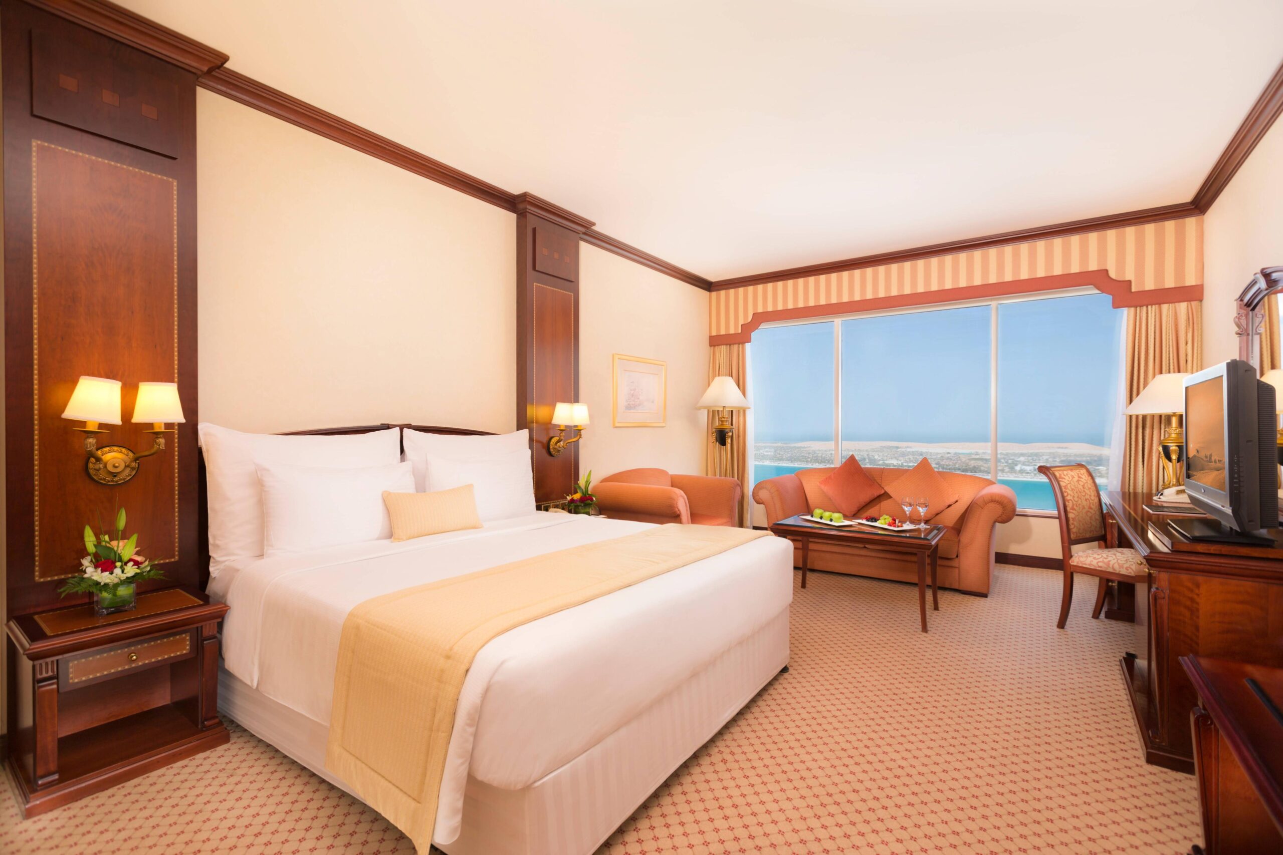 A junior suite with a sitting area and an Arabian Gulf view
