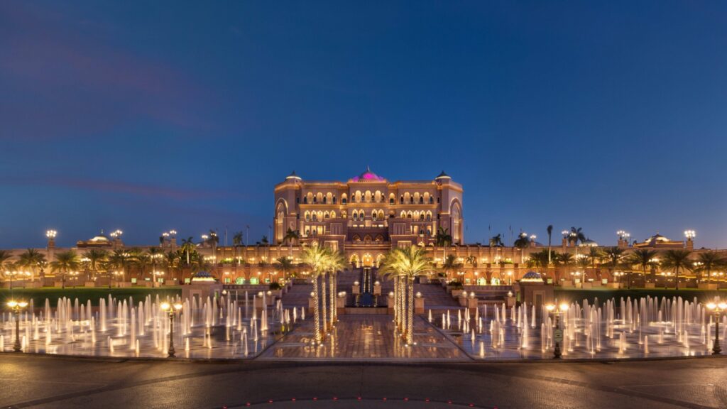 Emirates Palace Mandarin Oriental at night with illuminated fountains and the central palace façade.