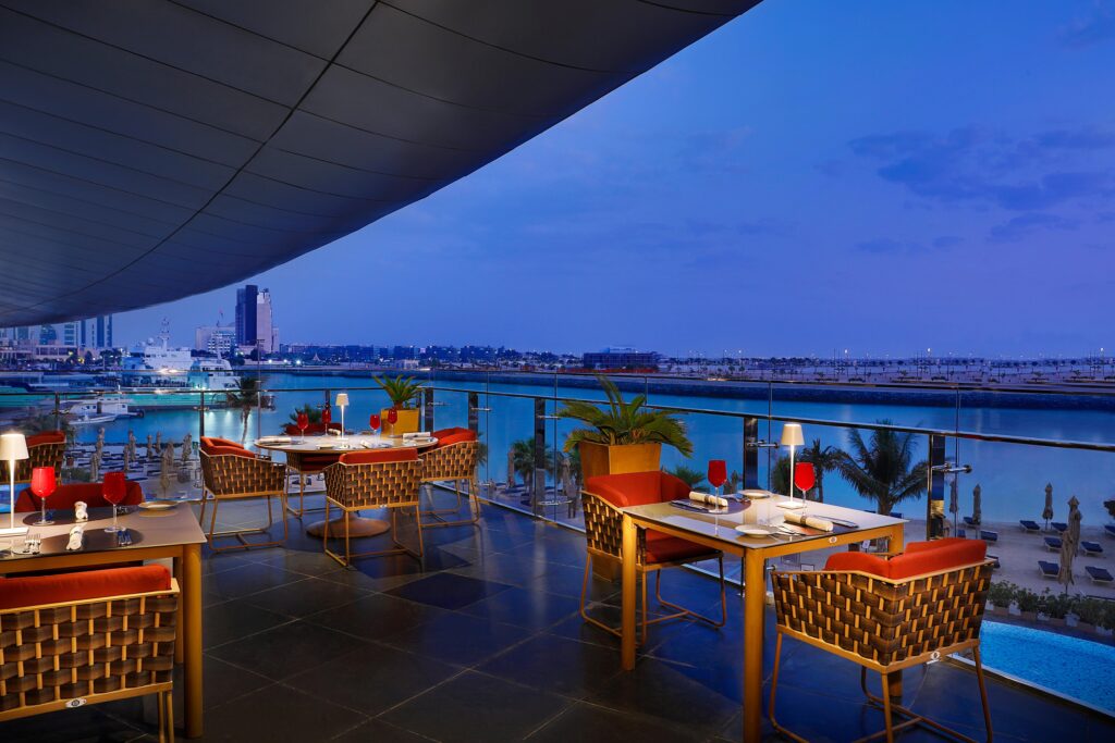 Waterfront terrace and Louvre Abu Dhabi architecture beside Fouquet's restaurant