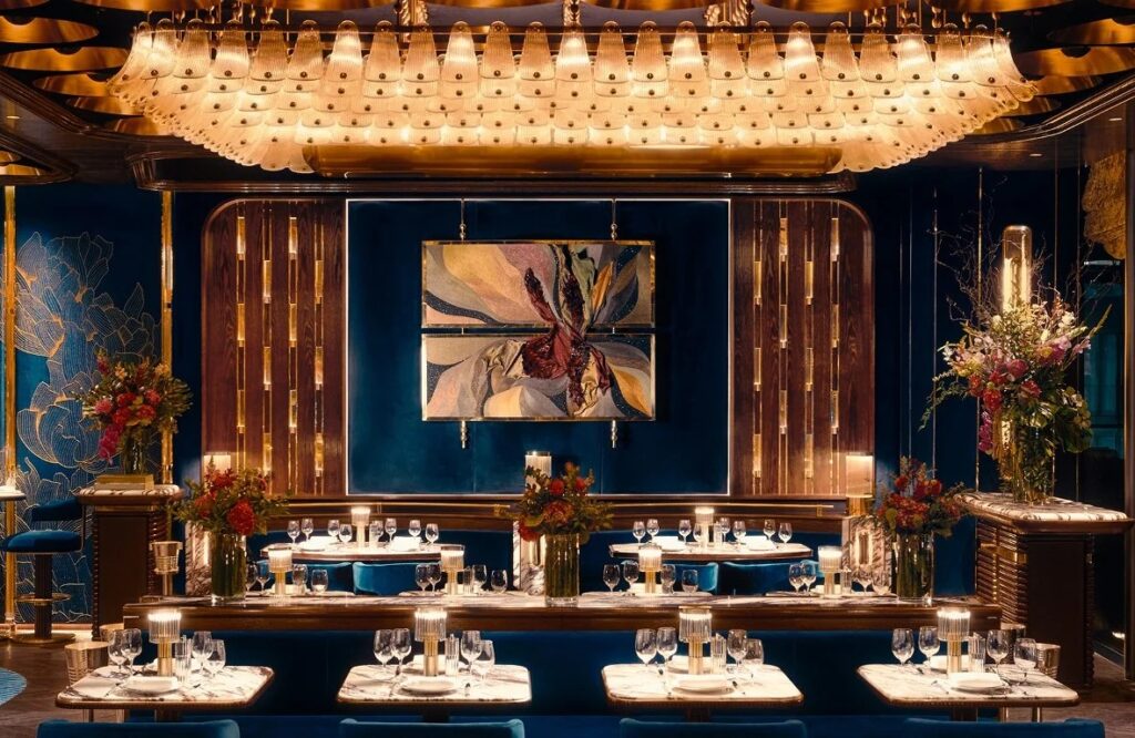 Isabel Abu Dhabi dining room with deep blue seating, polished brass and sculptural lighting