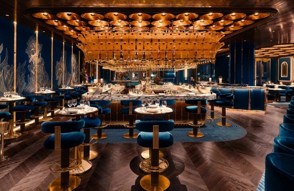 Central bar and blue velvet seating inside Isabel Abu Dhabi